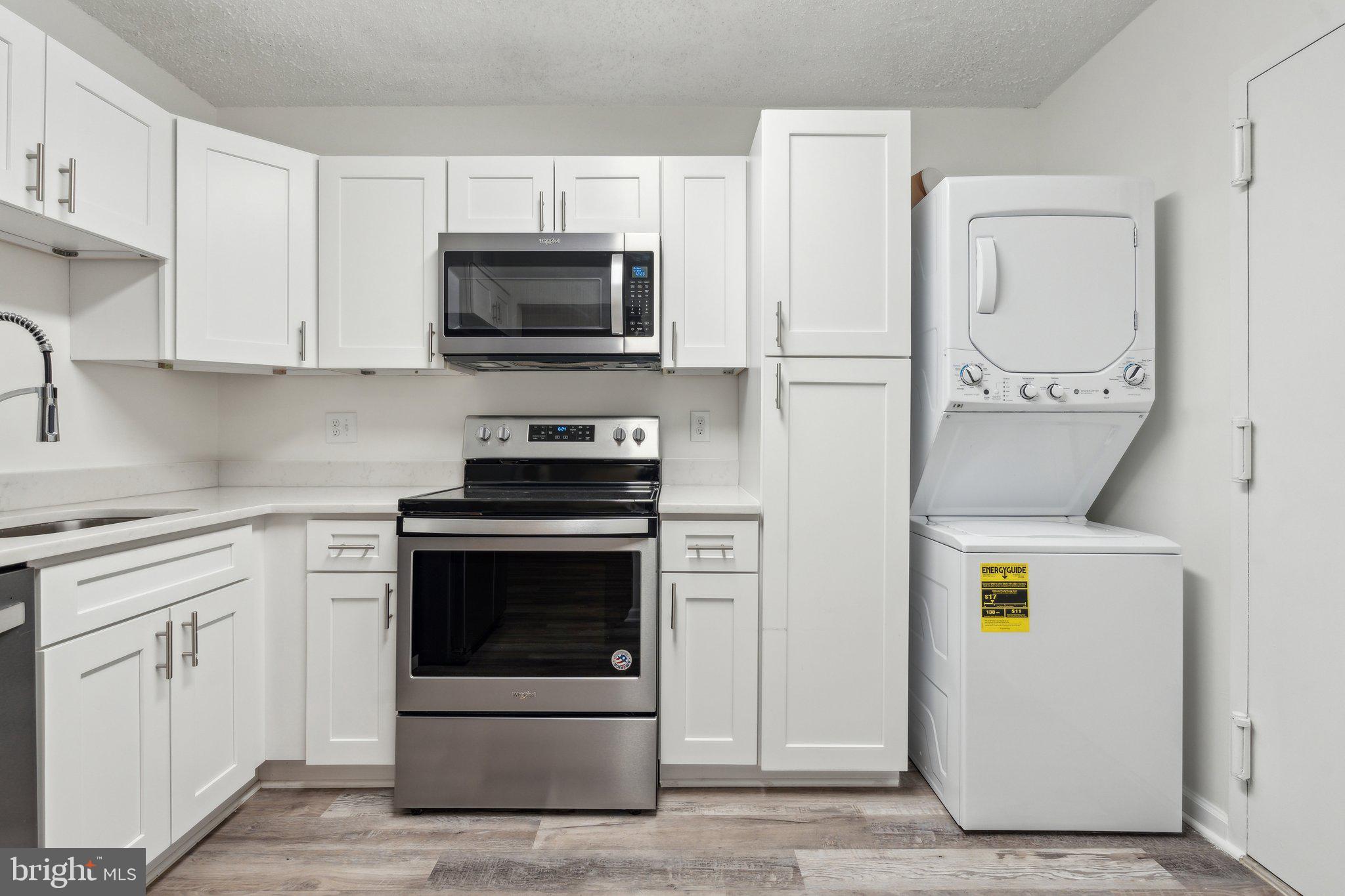 1800 Old Meadow Road, Unit 115 McLean, VA 22102 - Photo 18 of 35 a kitchen with stainless steel appliances a stove a microwave and a refrigerator