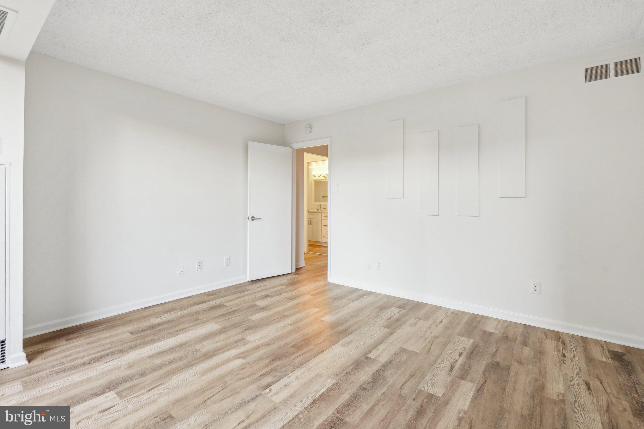 1800 Old Meadow Road, Unit 115 McLean, VA 22102 - Photo 21 of 35 a view of an empty room with wooden floor