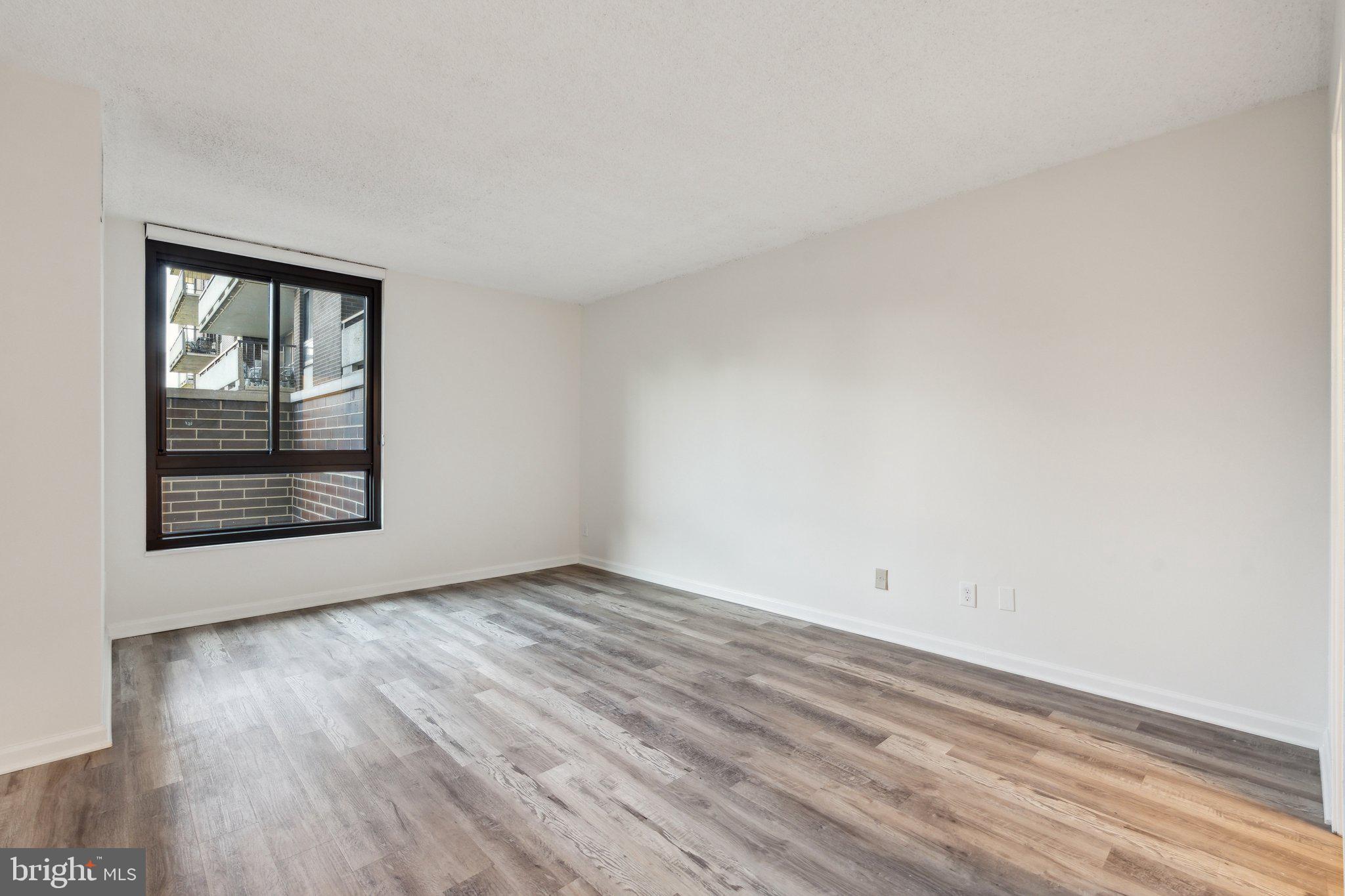 1800 Old Meadow Road, Unit 115 McLean, VA 22102 - Photo 25 of 35 an empty room with wooden floor and windows