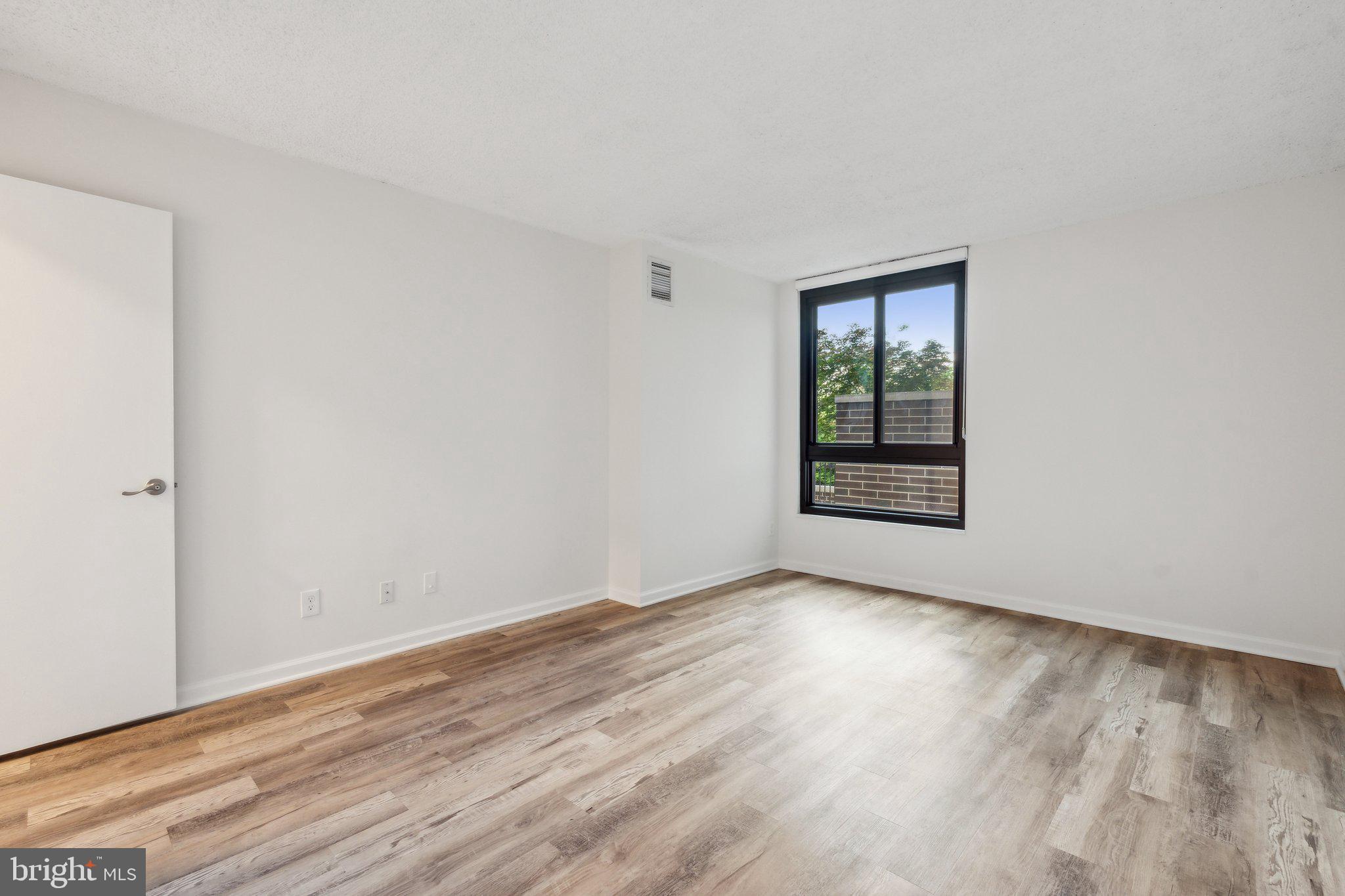 1800 Old Meadow Road, Unit 115 McLean, VA 22102 - Photo 27 of 35 an empty room with wooden floor and windows