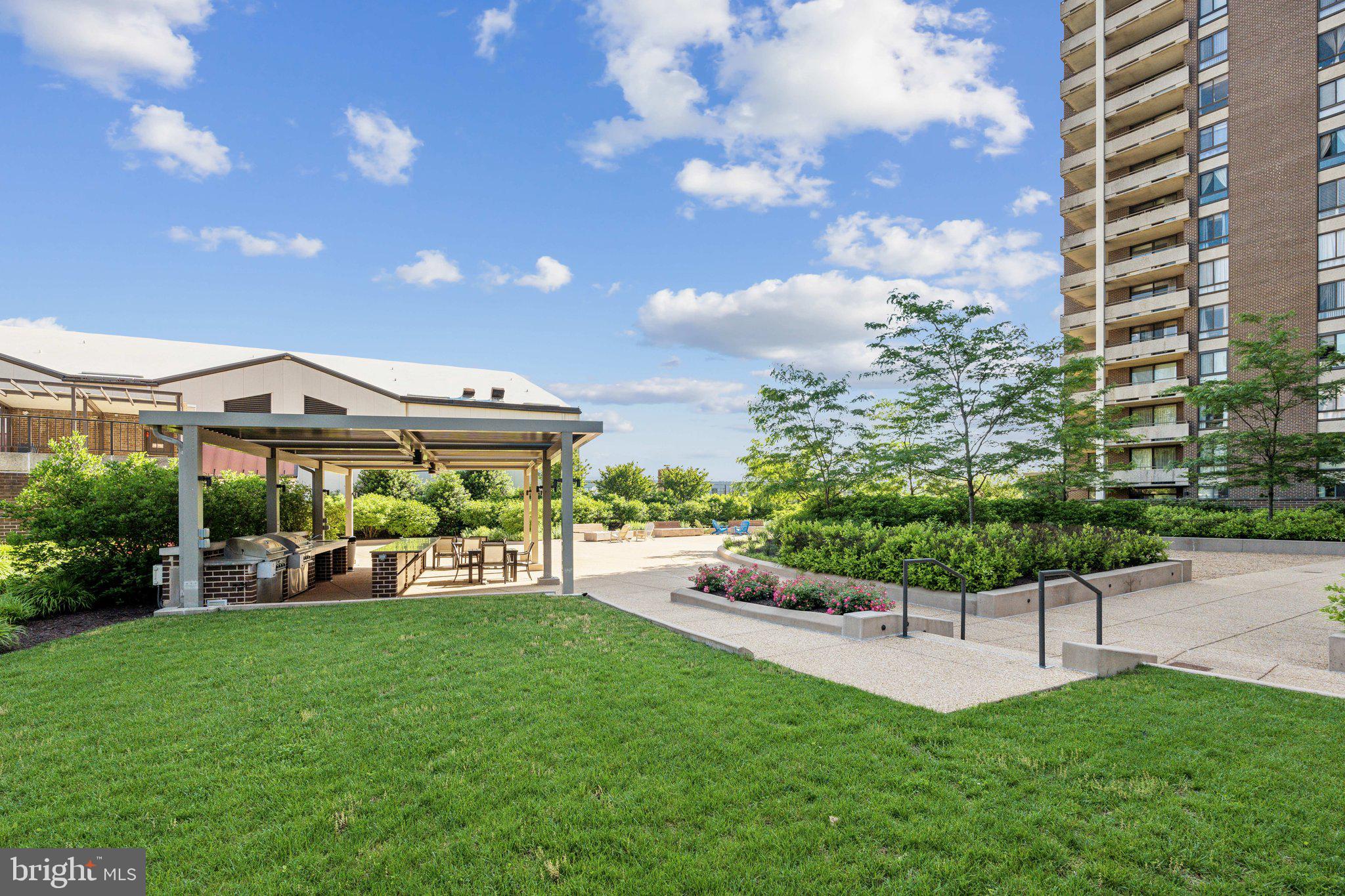 1800 Old Meadow Road, Unit 115 McLean, VA 22102 - Photo 32 of 35 a view of a garden with a bench in front of the house