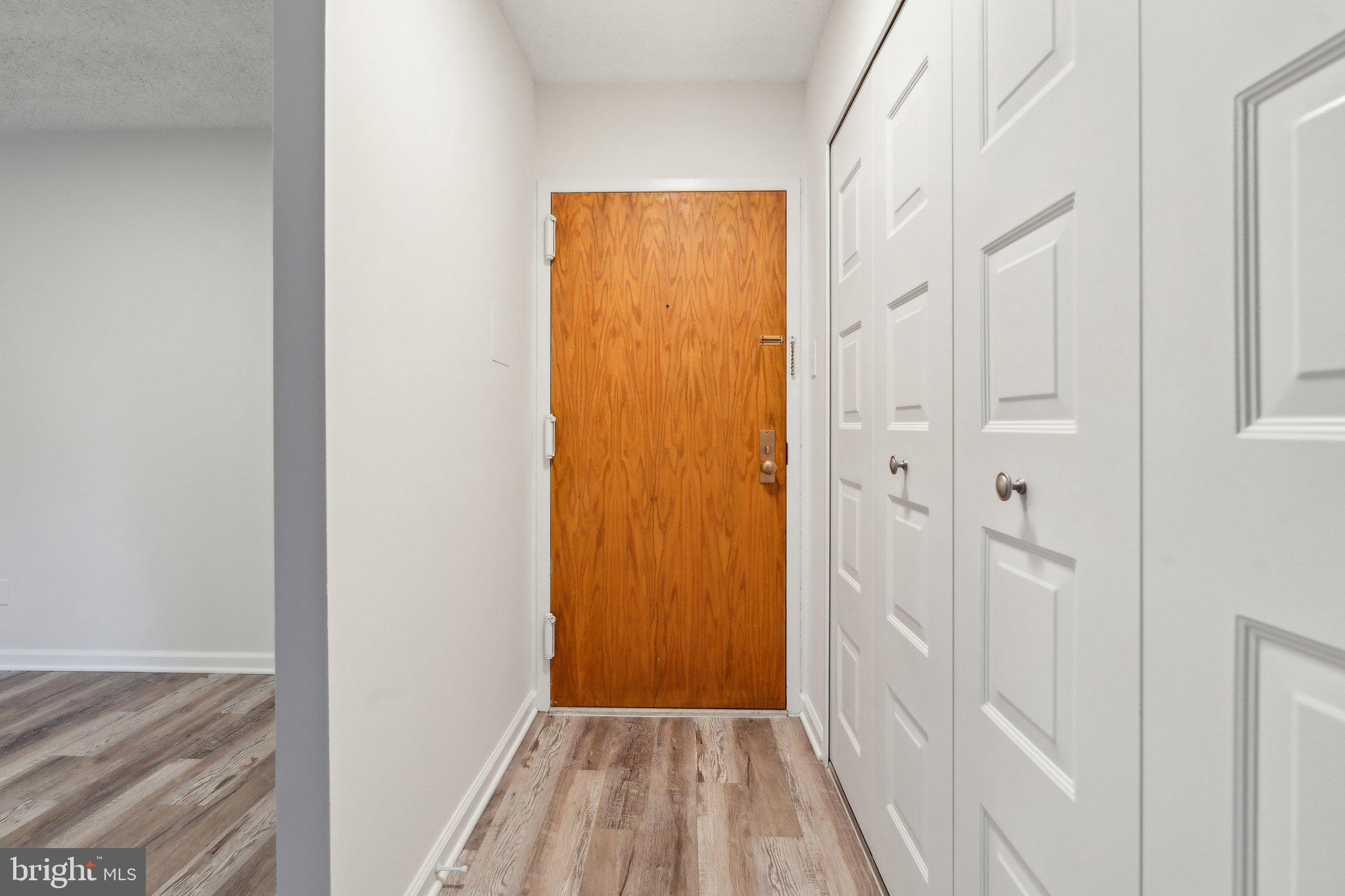 1800 Old Meadow Road, Unit 115 McLean, VA 22102 - Photo 7 of 35 a view of a hallway with wooden floor and a bathroom