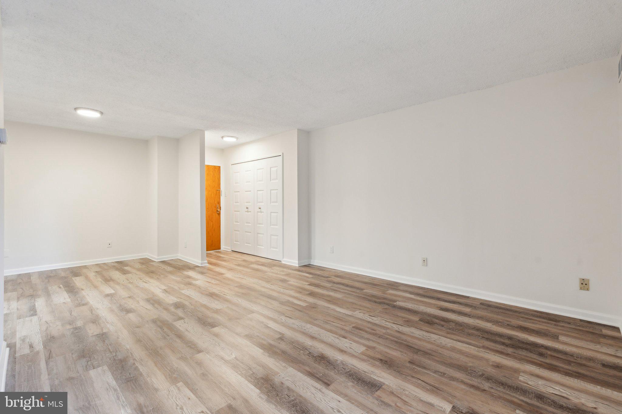 1800 Old Meadow Road, Unit 115 McLean, VA 22102 - Photo 9 of 35 a view of an empty room with wooden floor and a window