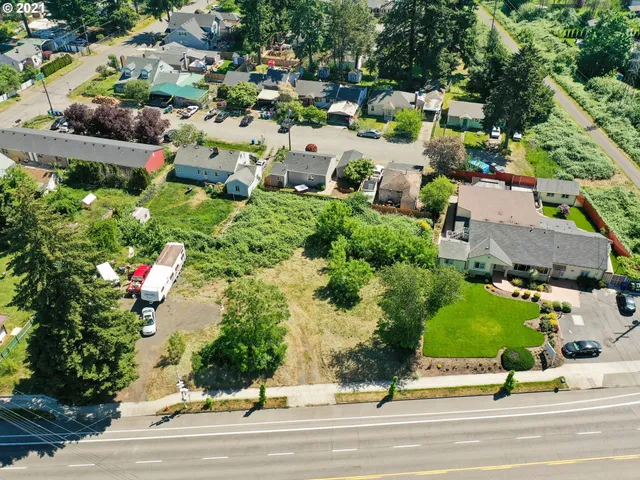 an aerial view of a houses with yard and street view