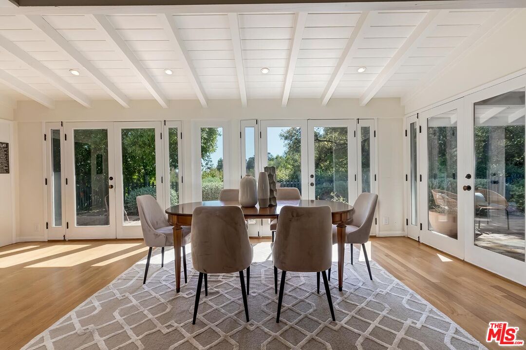 751 Teakwood Road Los Angeles, CA 90049 - Photo 17 of 46 a view of a dining room with furniture wooden floor and chandelier