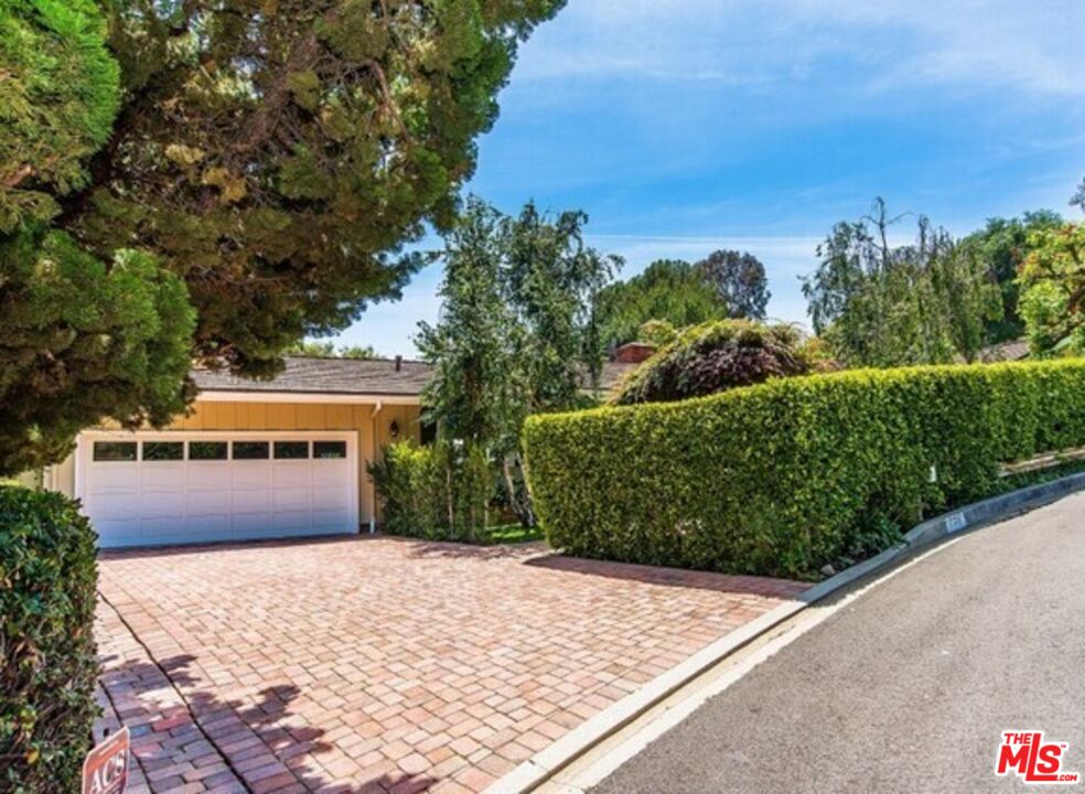 751 Teakwood Road Los Angeles, CA 90049 - Photo 2 of 46 a front view of a house with a yard and trees