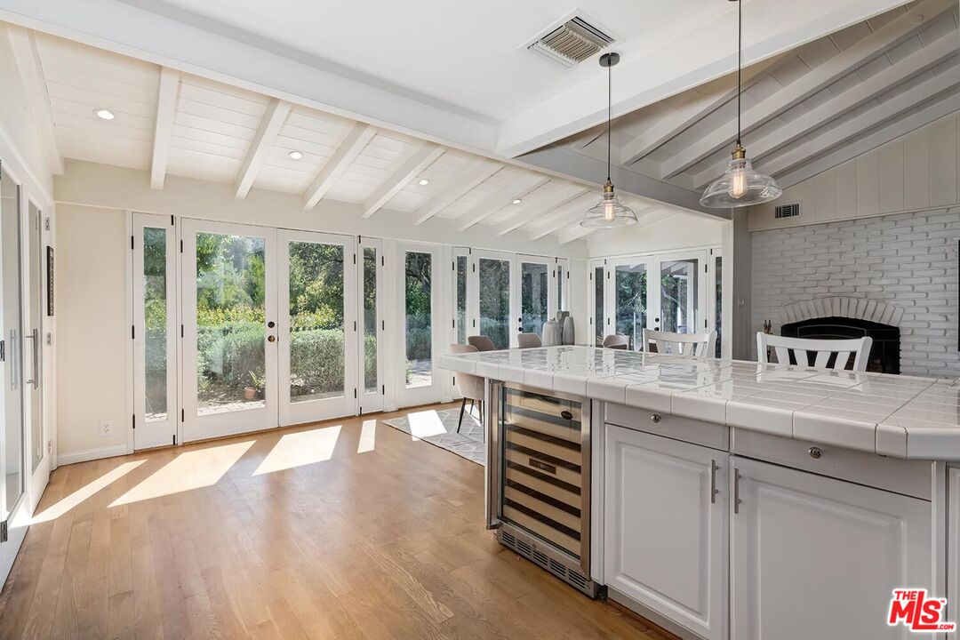 751 Teakwood Road Los Angeles, CA 90049 - Photo 23 of 46 a large kitchen with kitchen island granite countertop a large window and stainless steel appliances