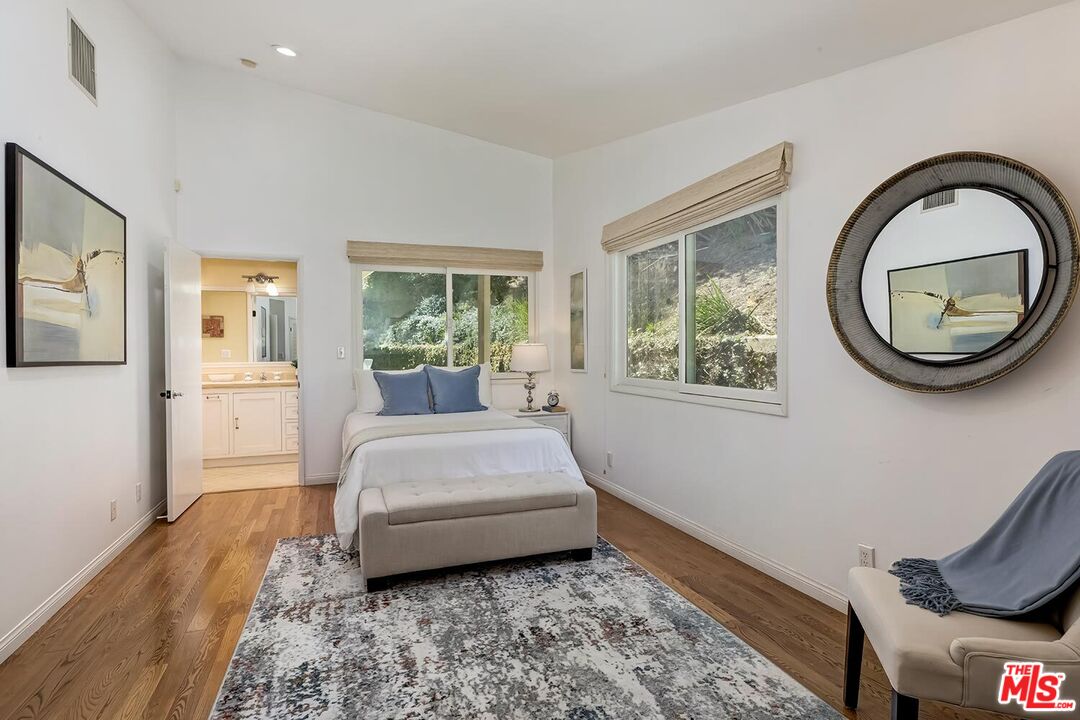 751 Teakwood Road Los Angeles, CA 90049 - Photo 33 of 46 a spacious bedroom with a bed and a large window