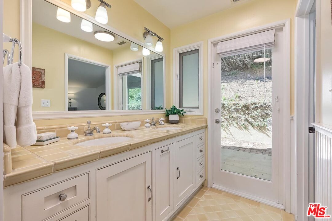 751 Teakwood Road Los Angeles, CA 90049 - Photo 35 of 46 a bathroom with a granite countertop sink mirror and double