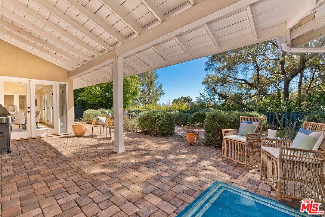 751 Teakwood Road Los Angeles, CA 90049 - Photo 44 of 46 a view of a patio with a dining table and chairs with wooden floor and fence