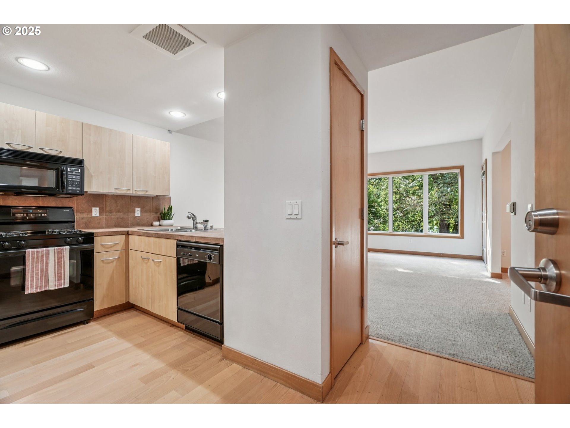 300 West 8th Street, Unit 206 Vancouver, WA 98660 - Photo 5 of 42 a kitchen with stainless steel appliances kitchen island granite countertop a stove a sink and a microwave