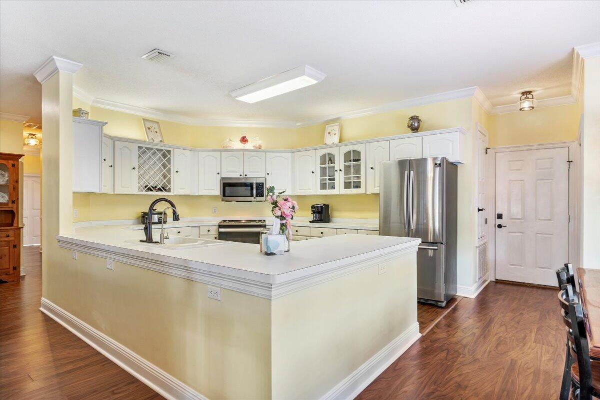 1830 Seahawk Lane Navarre, FL 32566 - Photo 15 of 53 a kitchen with stainless steel appliances a refrigerator a sink a stove a microwave a center island and cabinets