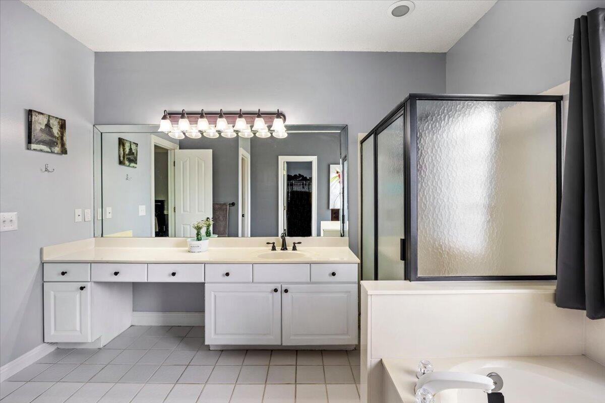 1830 Seahawk Lane Navarre, FL 32566 - Photo 33 of 53 a bathroom with a double vanity sink a mirror and a bathtub
