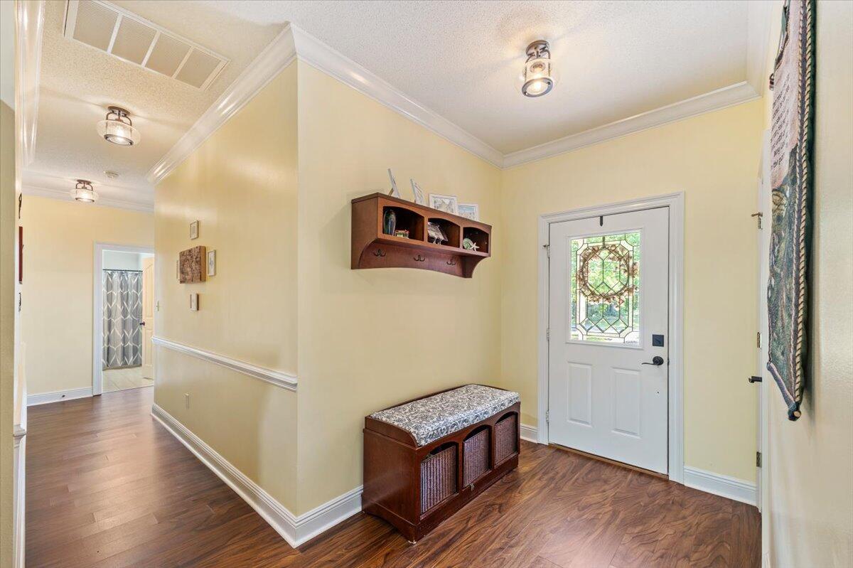 1830 Seahawk Lane Navarre, FL 32566 - Photo 7 of 53 a view of a hallway with wooden floor and windows