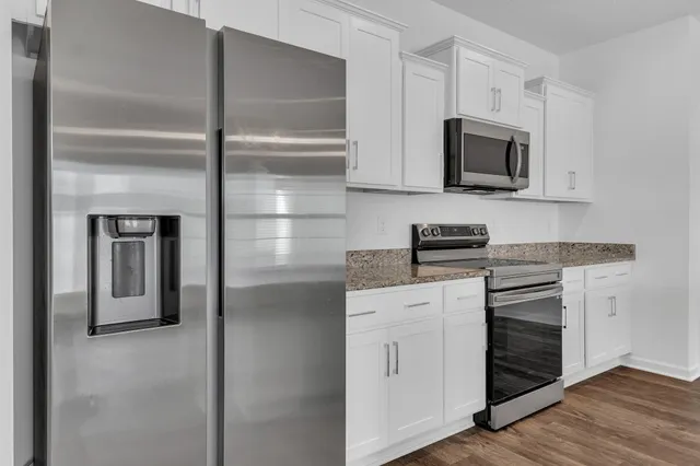 a kitchen with white cabinets and stainless steel appliances