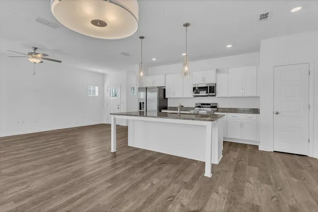 a kitchen with white cabinets stainless steel appliances and a center island