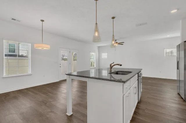a kitchen with stainless steel appliances granite countertop a sink stove and wooden floor