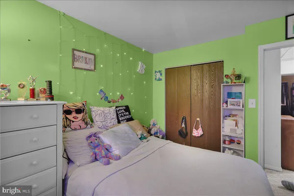 a bedroom with a bed and a refrigerator