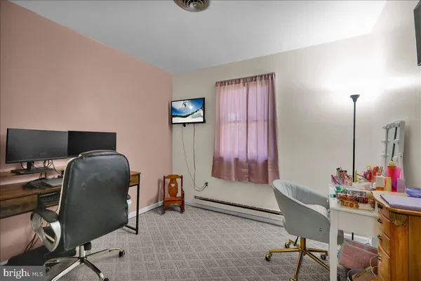 a view of a workspace with furniture and a window