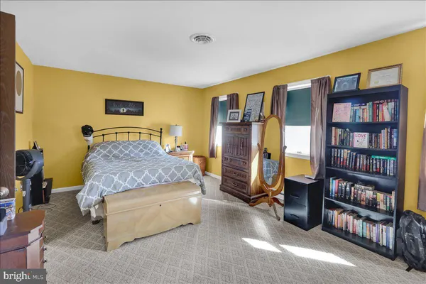 a bedroom with a large bed and a book shelf