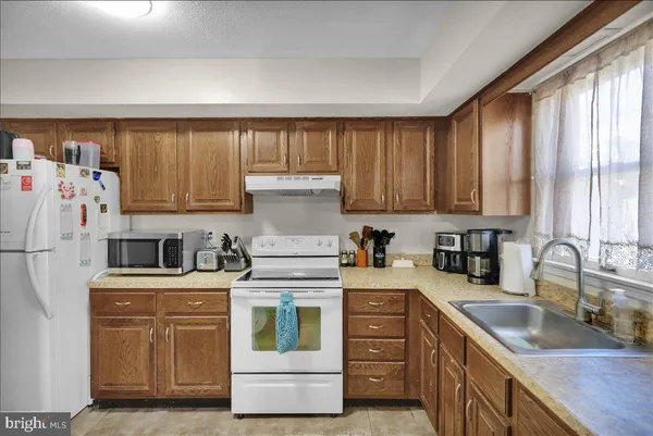 a kitchen with kitchen island a sink a stove and refrigerator