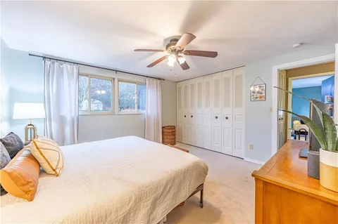 a bedroom with a bed and a flat tv screen on dresser