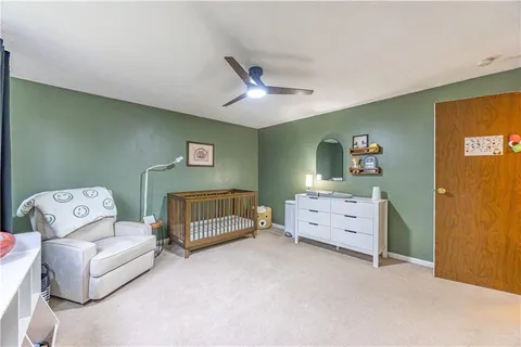 a view of an empty room with window and a ceiling fan
