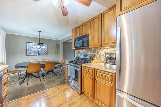a kitchen with stainless steel appliances granite countertop a stove and a refrigerator