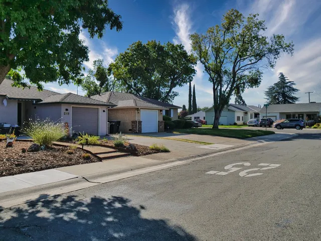 a front view of a house with garden and parking