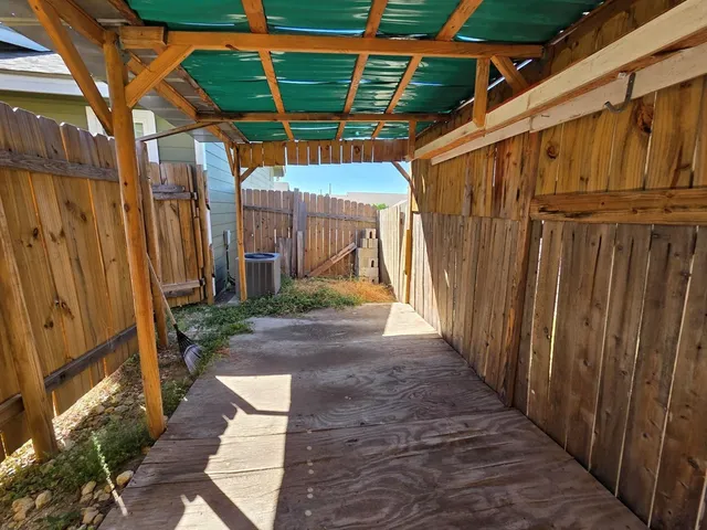 a view of a back yard with wooden fence