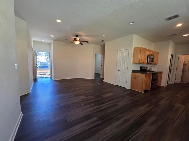 a view of empty room with wooden floor