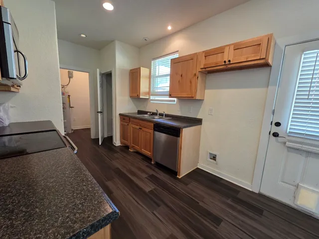 a kitchen with stainless steel appliances granite countertop a refrigerator and a stove