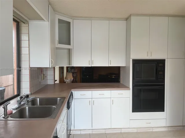 a kitchen with stainless steel appliances granite countertop a stove sink and cabinets