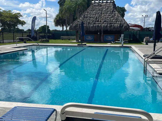 a view of swimming pool with a table and chairs under an umbrella