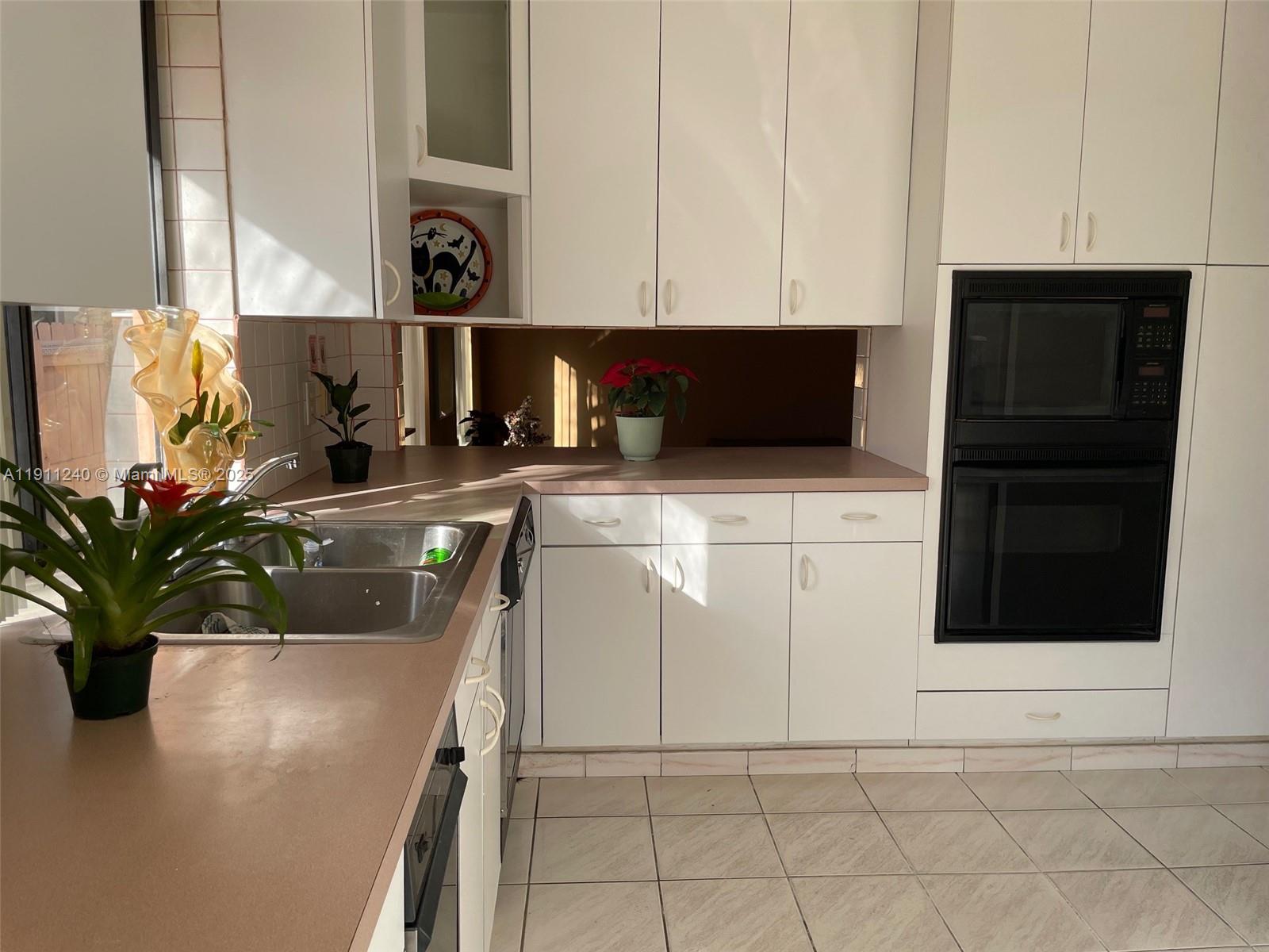 14604 Southwest 60th Terrace Miami, FL 33183 - Photo 46 of 55 a kitchen with stainless steel appliances a sink a microwave and cabinets