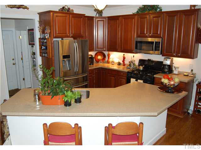 3733 Old Post Road Raleigh, NC 27612 - Photo 7 of 25 a kitchen with stainless steel appliances granite countertop a refrigerator and a wooden cabinets