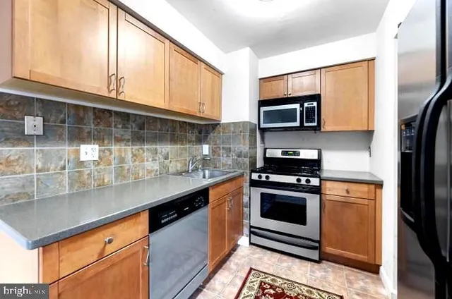 a kitchen with stainless steel appliances granite countertop a stove microwave and sink