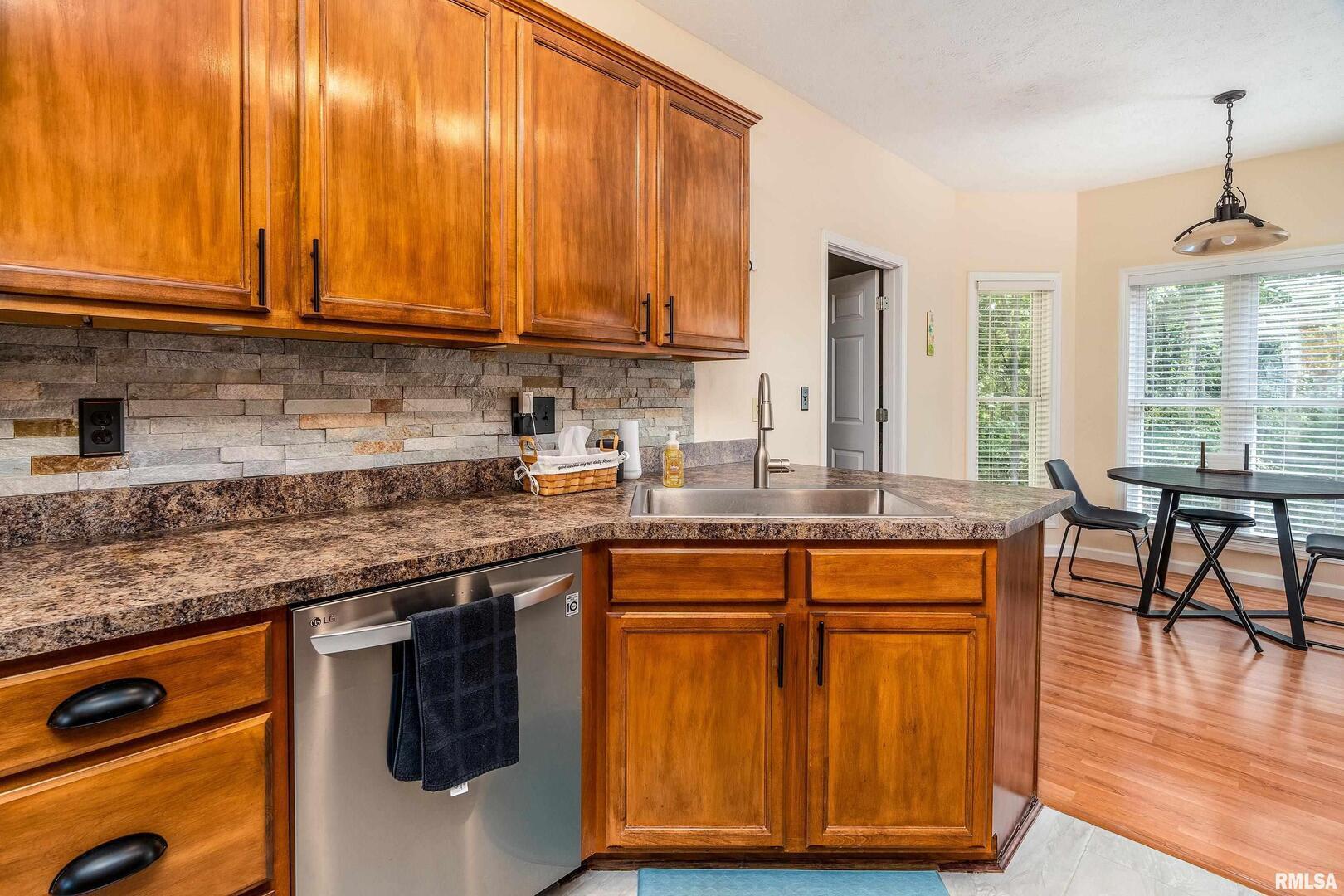 145 Oakview Road Carbondale, IL 62901 - Photo 9 of 42 a kitchen with stainless steel appliances granite countertop wooden cabinets a stove a sink and a large window