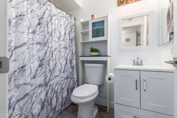 a bathroom with a toilet sink and mirror