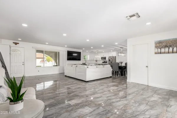a living room with furniture kitchen view and a potted plant