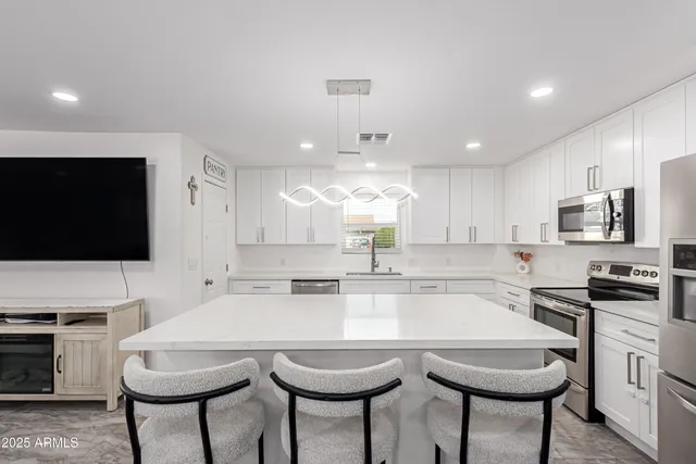 a kitchen with microwave a stove and chairs