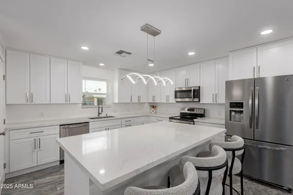 a kitchen with a refrigerator a sink a stove a microwave and cabinets