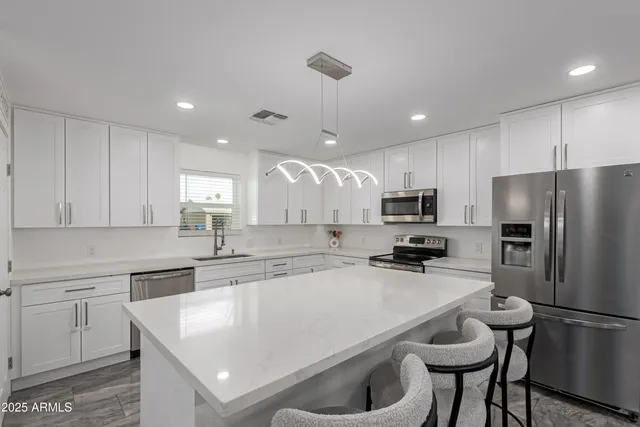 a kitchen with a refrigerator a sink a stove a microwave and cabinets