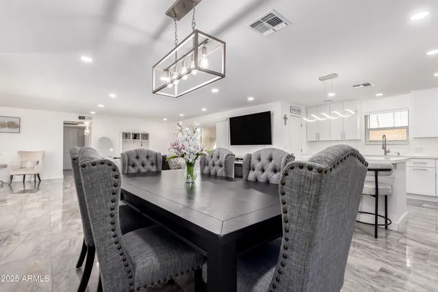 a kitchen with a dining table chairs and a chandelier