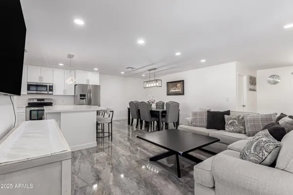 a living room with lots of furniture and kitchen view