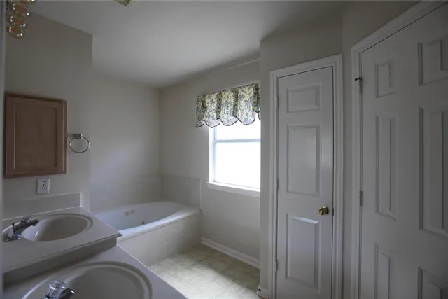 a bathroom with a tub sink and mirror