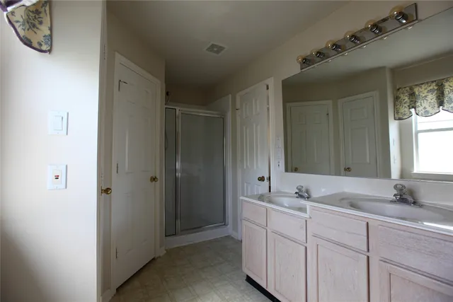 a bathroom with a double vanity sink and mirror