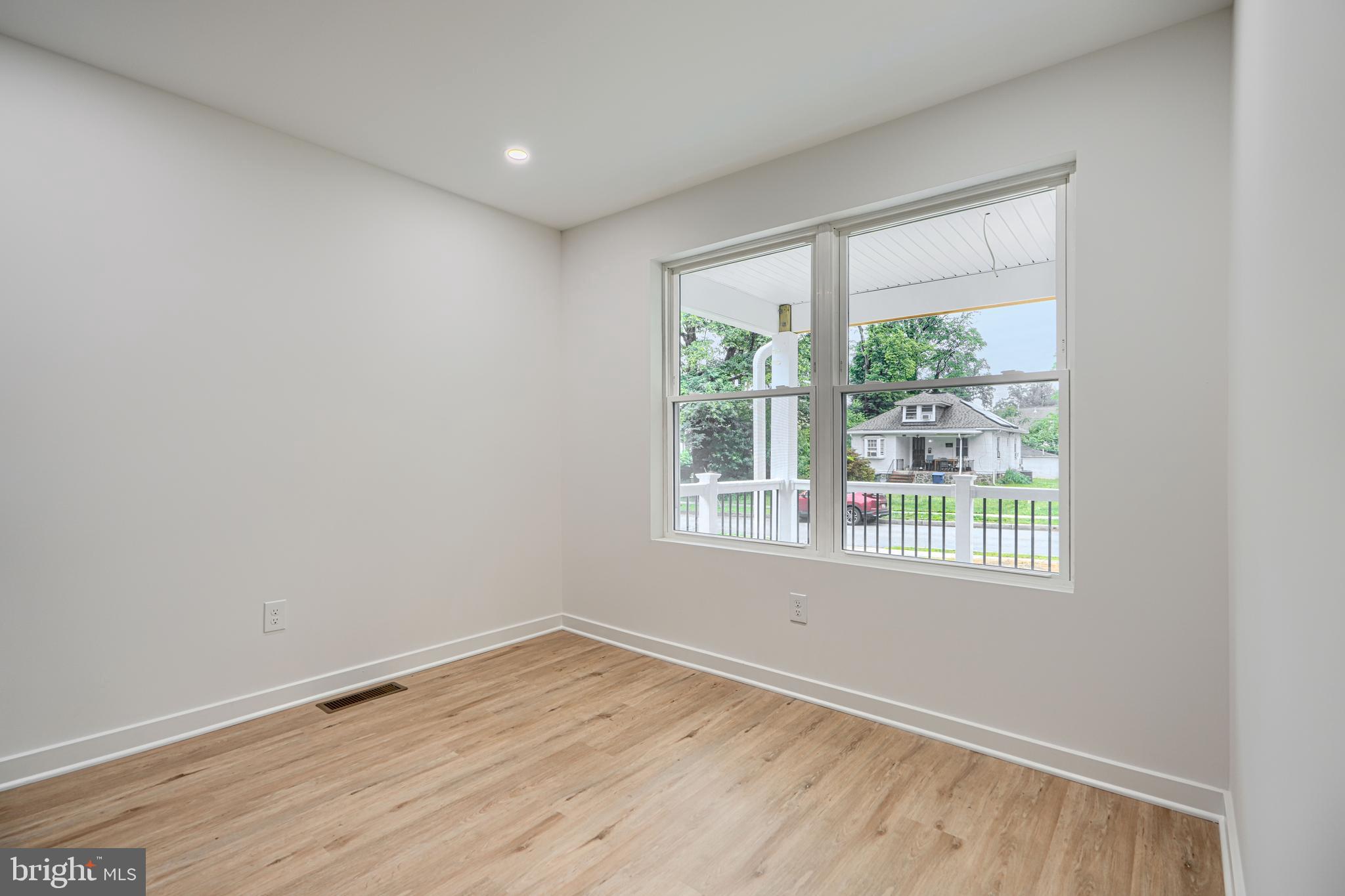 3410 Pinkney Road Baltimore, MD 21215 - Photo 16 of 55 an empty room with wooden floor and windows