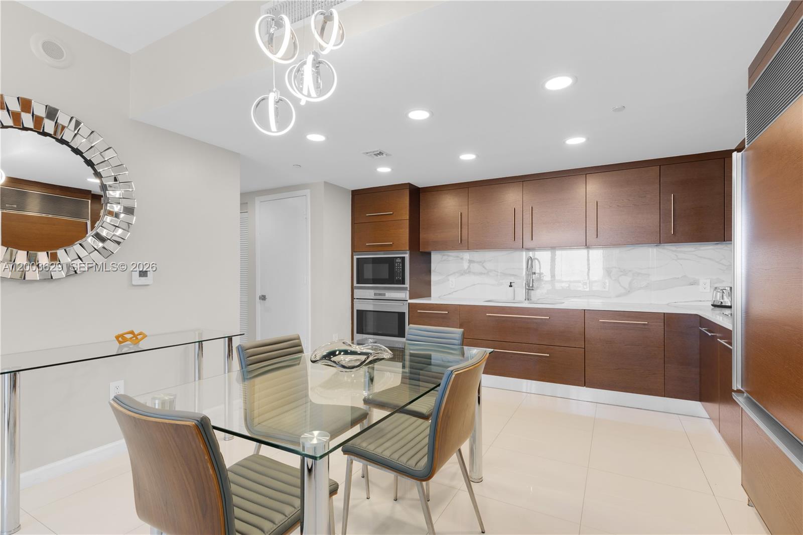 485 Brickell Avenue, Unit 4501 Miami, FL 33131 - Photo 11 of 49 a kitchen with stainless steel appliances granite countertop a sink a microwave refrigerator and chairs