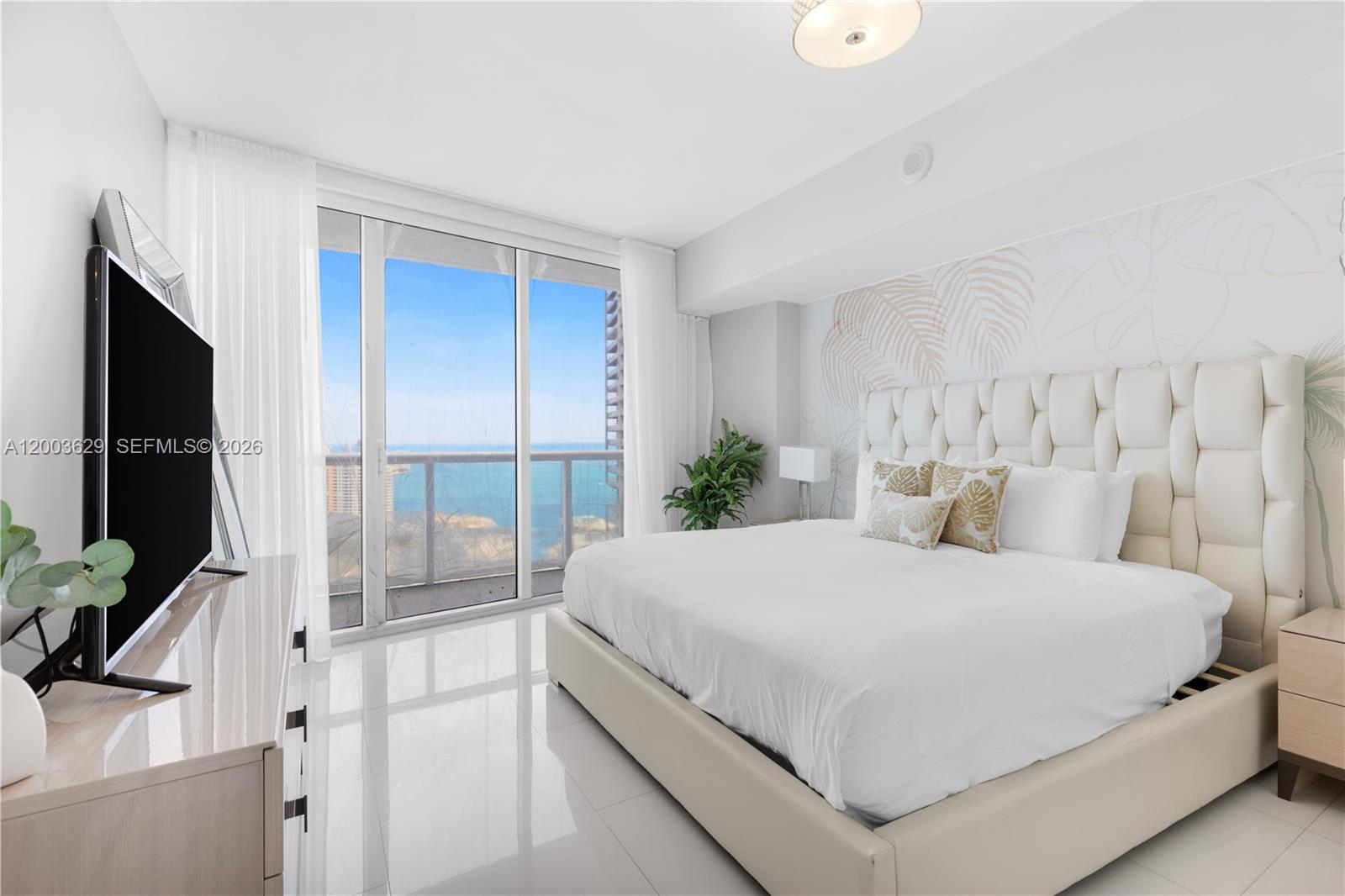 485 Brickell Avenue, Unit 4501 Miami, FL 33131 - Photo 14 of 49 a bedroom with a large bed and a flat tv screen on dresser